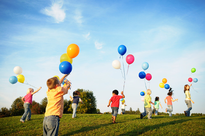 一群孩子拿著氣球在陽光下奔跑圖片下載