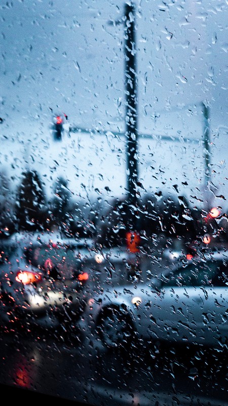 在雨季透過濕玻璃窗看到的汽車圖片素材