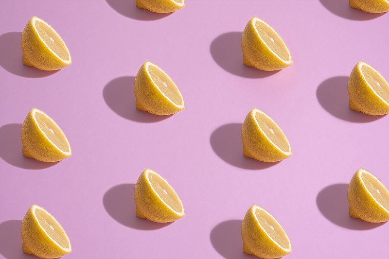 粉色背景上的檸檬片特寫圖片素材