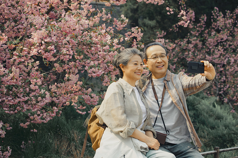 老年人City walk系列:老年夫妻在北京北海公园花海旁自拍图片下载