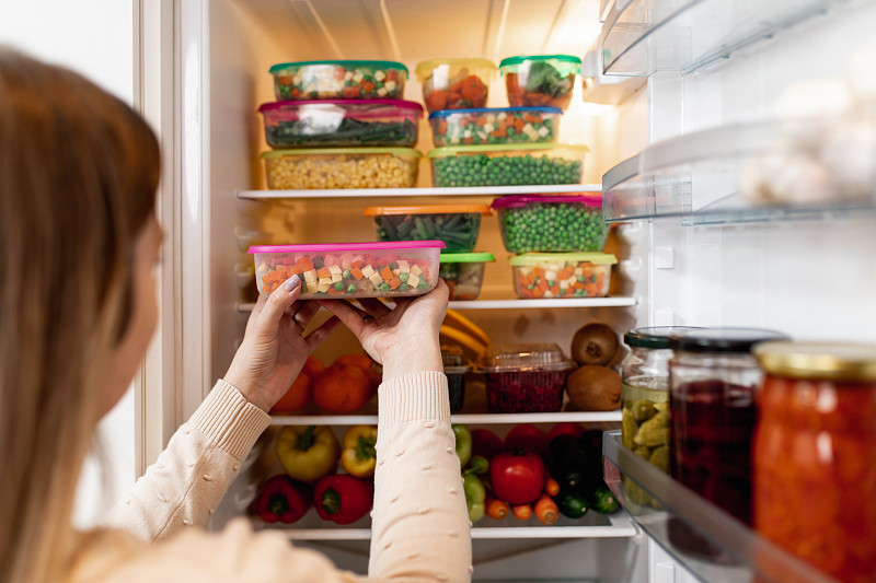 從冰箱里拿生食物的女人圖片素材
