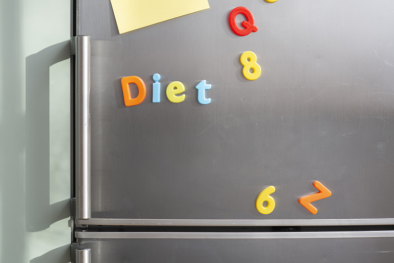 銀色冰箱門上的冰箱貼寫著“節食”圖片素材
