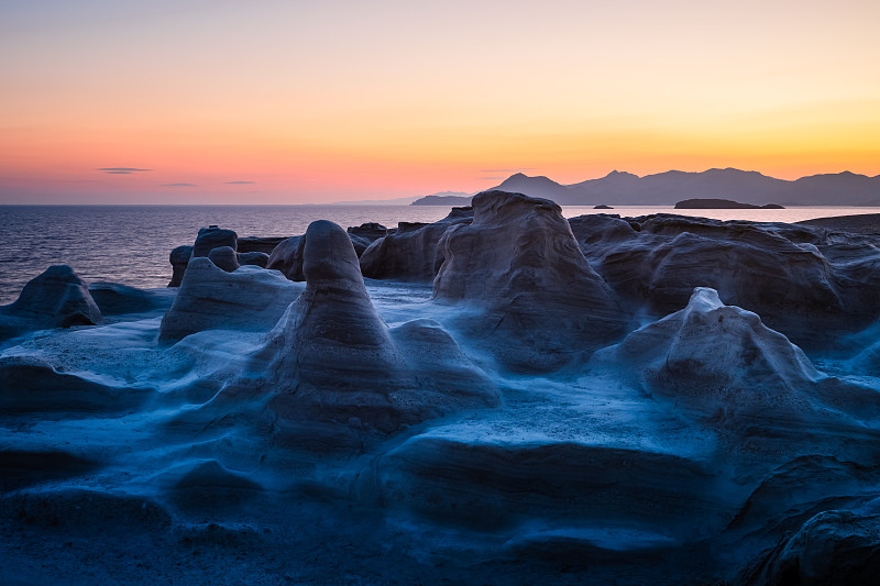 日出時的火山巖層，米洛斯，希臘攝影圖片