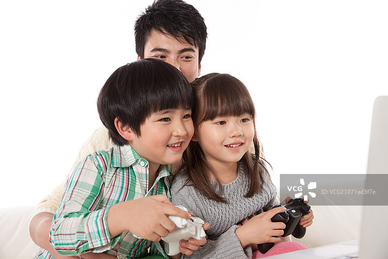 父亲和儿女坐在沙发上打游戏图片素材