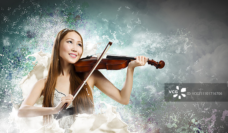 小提琴家的女人。年轻漂亮的亚洲女人拉小提琴。年轻人才图片素材