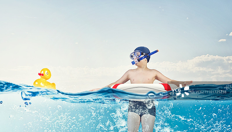 我伟大的暑假。小学生戴着潜水面罩在救生圈里游泳图片素材