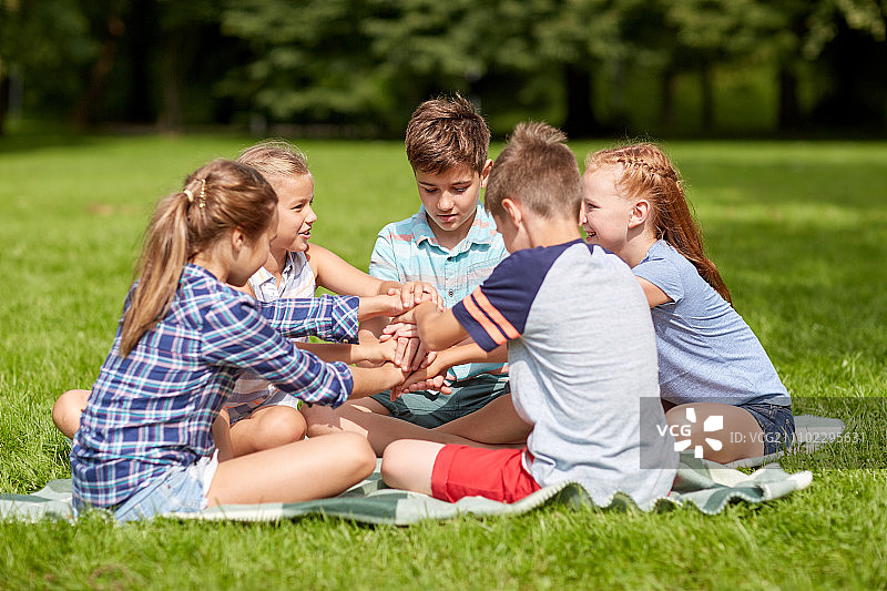 暑假，友谊，童年，休闲和人的概念-一群快乐的十几岁前的孩子在公园牵手图片素材