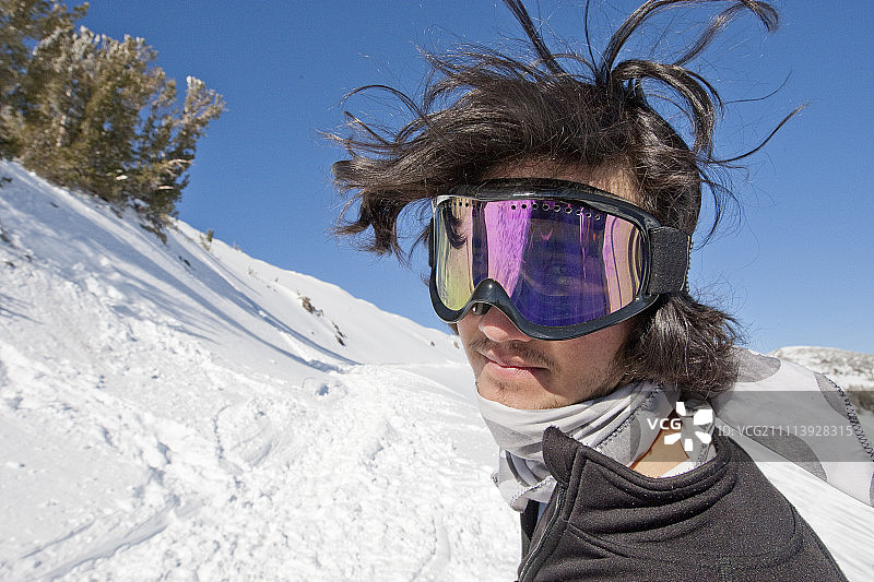 一头乱发的年轻男性滑雪运动员被抓拍到了。图片素材