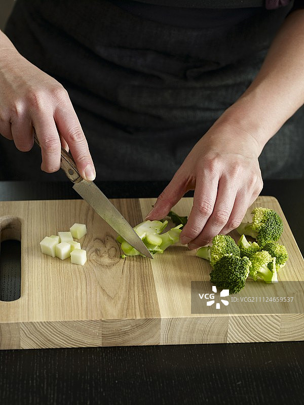 在切菜板上手工切花椰菜的特写，第一步图片素材