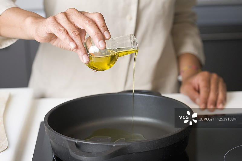 往煎锅里倒一点橄榄油图片素材