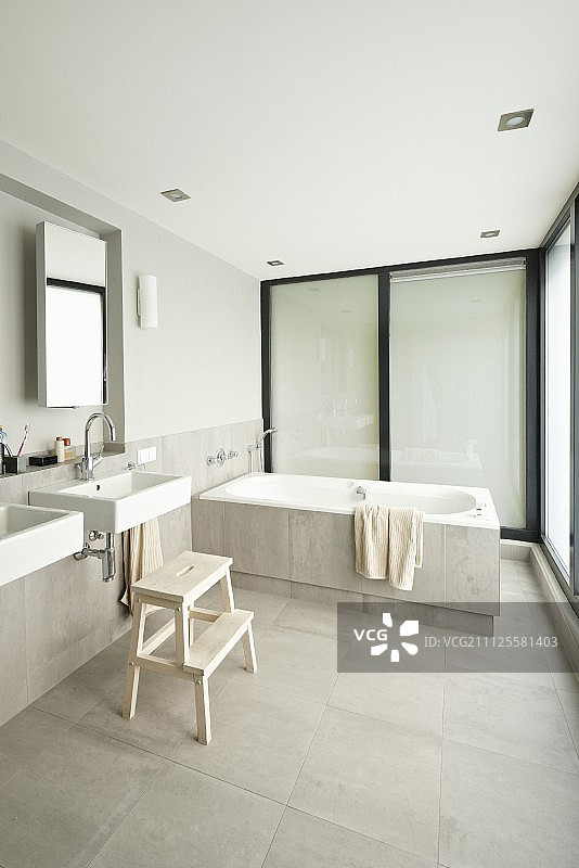 极简设计的浴室，在壁龛和浴缸的镜子下面有水池图片素材