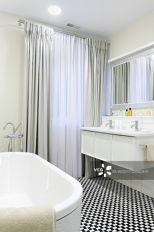 黑色和白色马赛克地板在优雅的浴室与地长窗帘图片素材