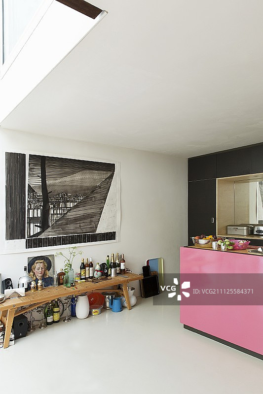 瓶子放在下面的木凳上，画在墙上，厨房柜台上的一面是粉红色的图片素材