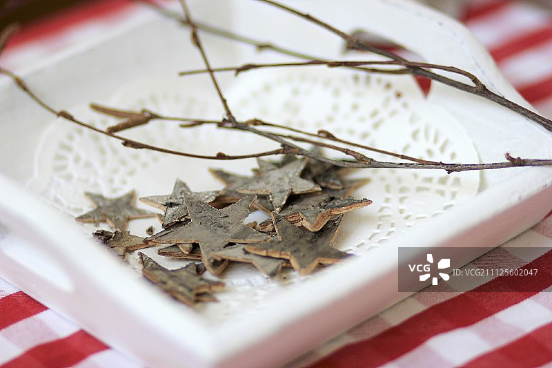用树皮做成的星星装饰放在木托盘上图片素材