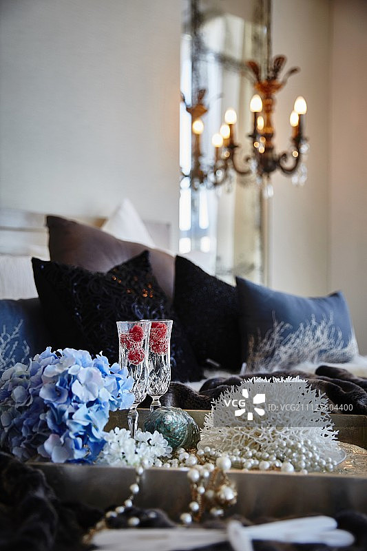 卧室里放着蓝色的绣球花、香槟杯和珠子项链图片素材