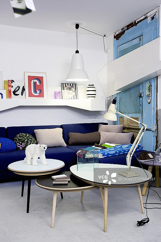 一组咖啡桌，前面是宝蓝色的沙发和白色壁挂式的架子，内饰折衷图片素材