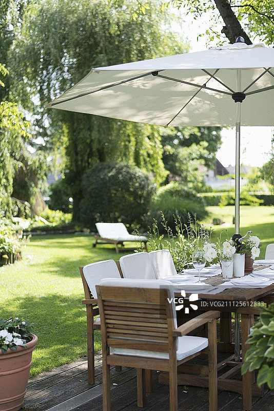 在整洁的花园阳伞下布置餐桌图片素材