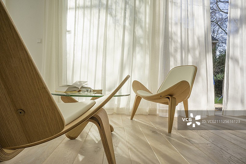 橡木地板上的Wegner Shell椅，前面挂着通风的窗帘图片素材