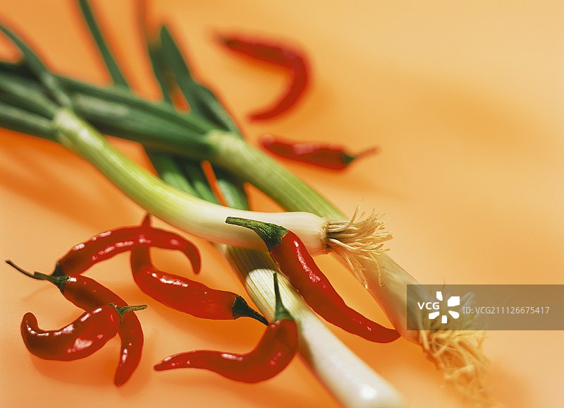 红辣椒和葱的背景是橙色的图片素材