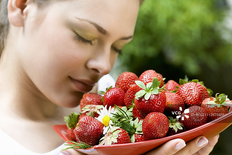 年轻女子和新鲜的草莓图片素材