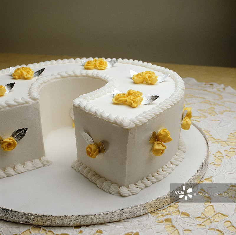一个白色的蛋糕，上面有黄色的糖玫瑰图片素材