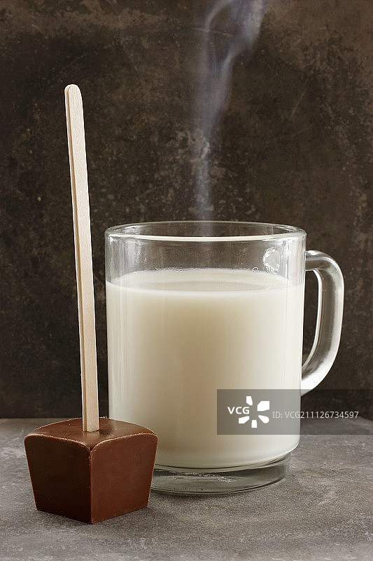 热牛奶和一块巧克力蘸着吃图片素材