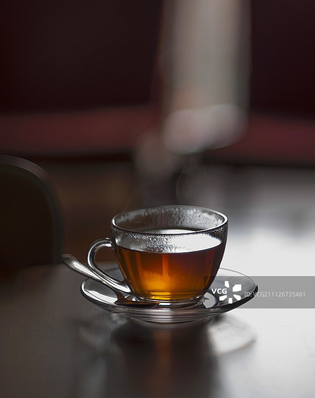 客厅桌子上的一杯热气腾腾的热茶(选择性聚焦)图片素材