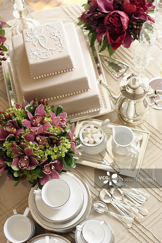三层白色婚礼蛋糕、鲜花、茶具图片素材