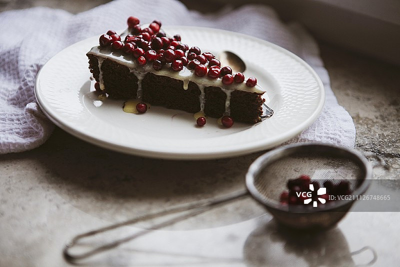 一块有蔓越莓和糖霜的巧克力蛋糕图片素材