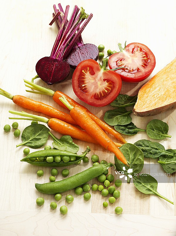 一种以豌豆、胡萝卜、菠菜、西红柿和甜菜根为特色的蔬菜图片素材