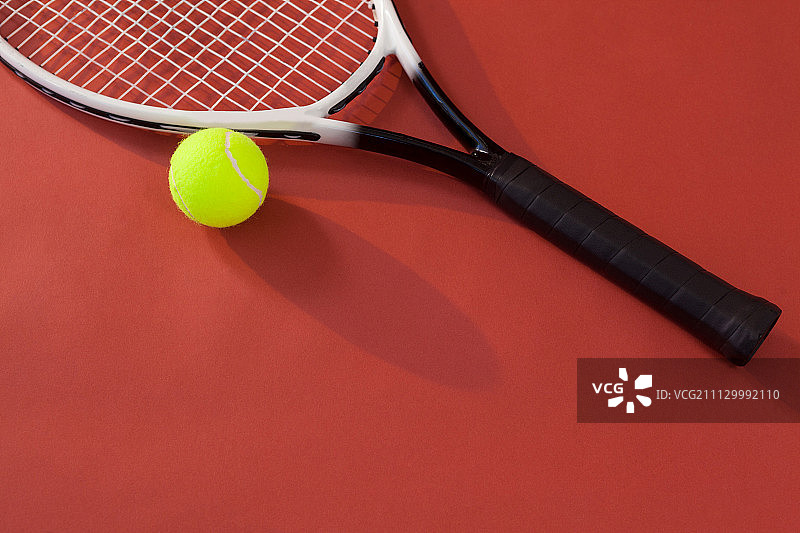 高角度的网球拍和球反对栗色的背景图片素材
