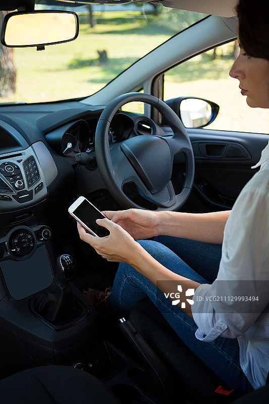 女人在车里用手机的侧视图图片素材