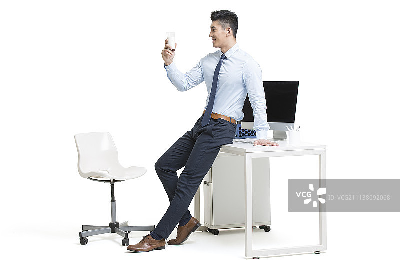 年轻商务男士在办公室喝牛奶图片素材