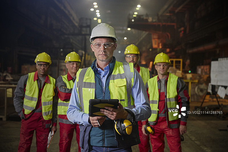 描绘钢铁厂自信的主管和钢铁工人图片素材