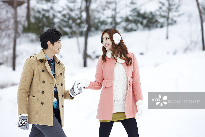 一对情侣在雪地上行走的照片图片素材