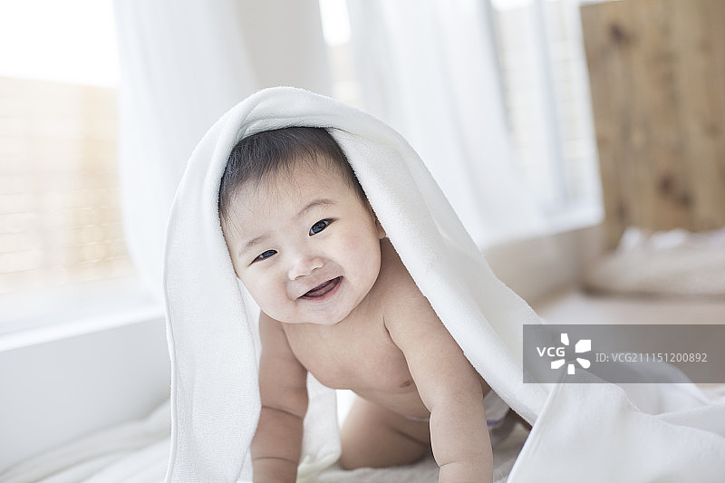 用毛巾裹着的男婴微笑着图片素材