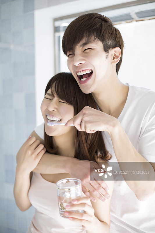 男人一边给女人刷牙一边玩图片素材