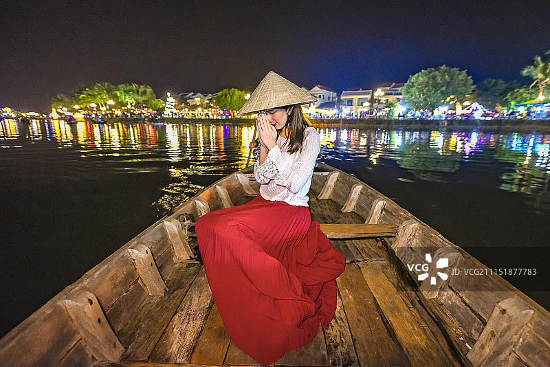 越南会安古镇，一名女孩在船上祈祷图片素材