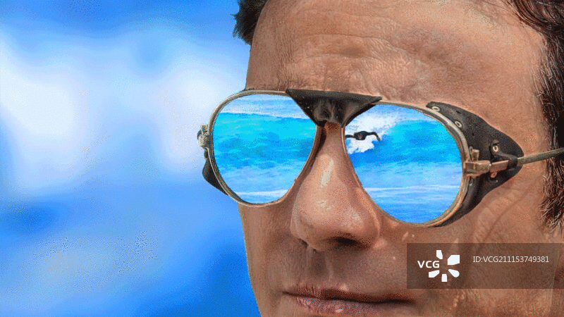 冲浪者在男人的太阳镜上反射海浪图片素材