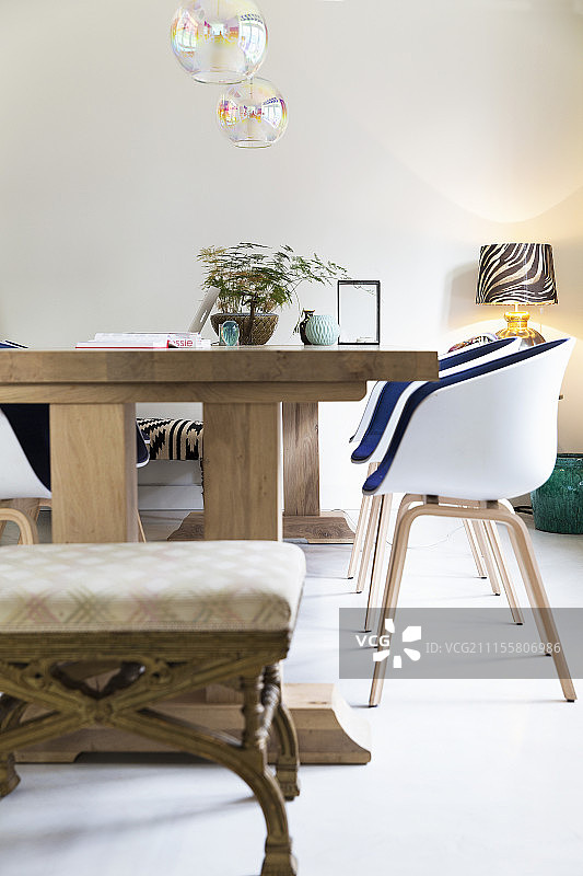 现代贝壳椅和旧凳子周围的木桌图片素材