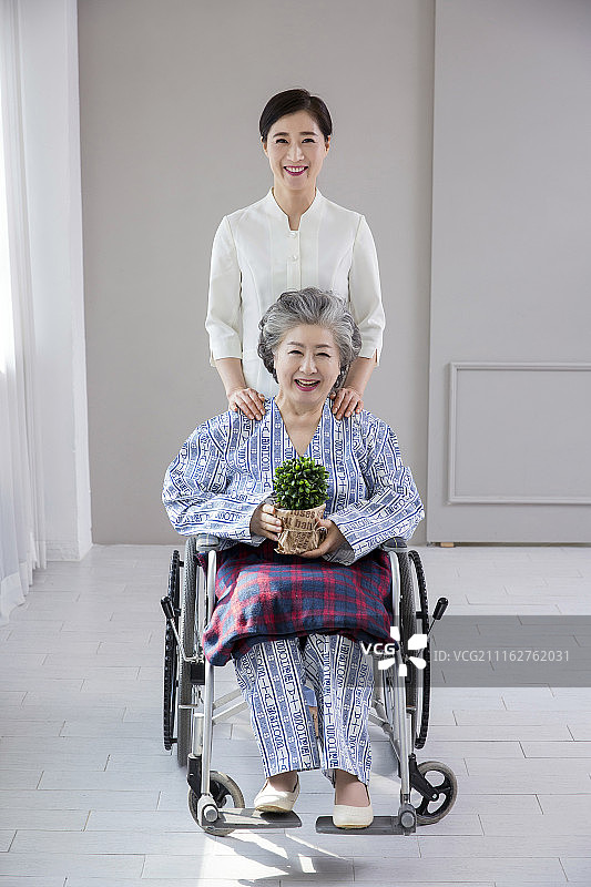护士协助坐在轮椅上的老妇人的照片。关爱老人的概念照片。085图片素材