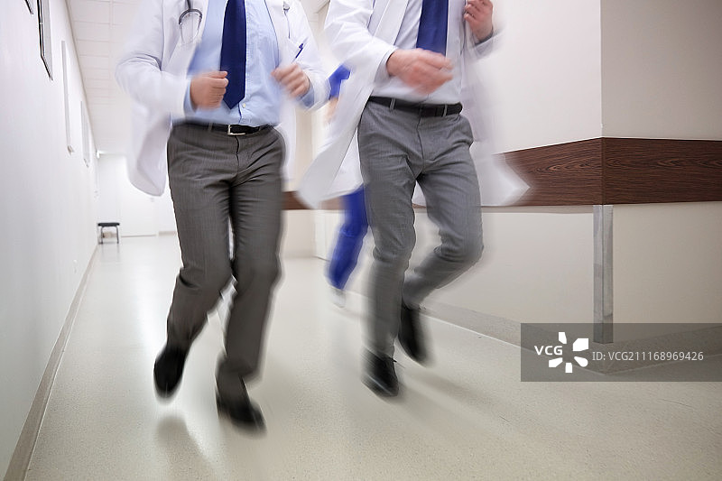 人、保健和医学概念-一组医护人员沿着医院跑(运动模糊效应)。医护人员或医生在医院跑步的特写图片素材
