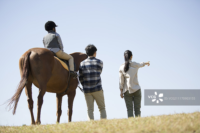 快乐一家人在草地骑马图片素材