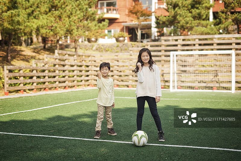 弟弟和妹妹踢足球的照片图片素材