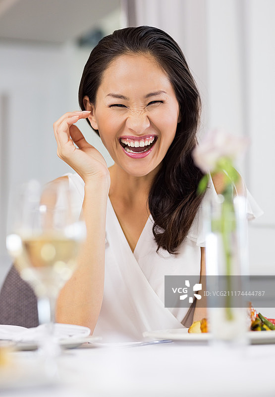 一个在餐桌上笑着的女人的肖像图片素材