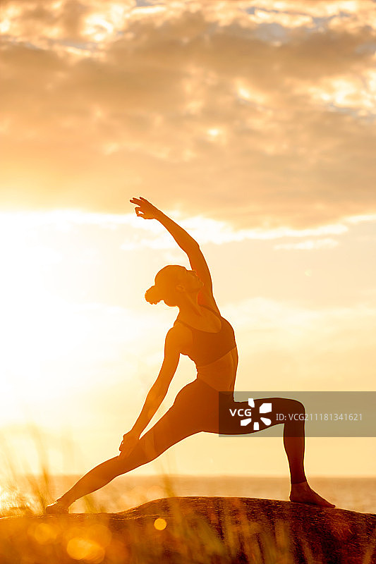 白人健身妇女练习瑜伽。日落时分练习瑜伽的白人健身女性图片素材