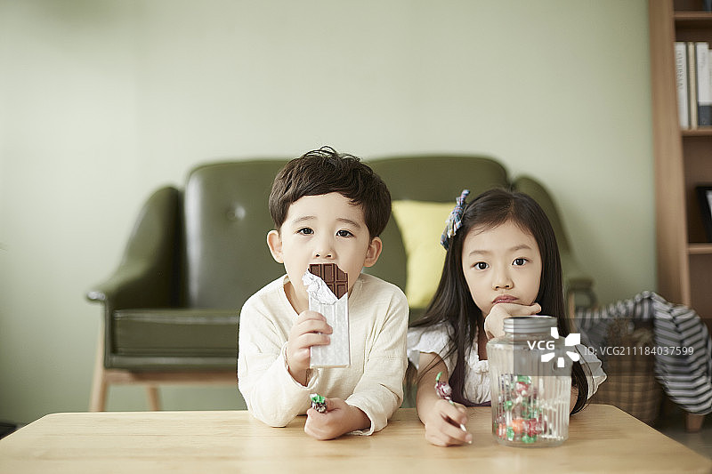 小男孩和小女孩在客厅吃甜点的照片图片素材