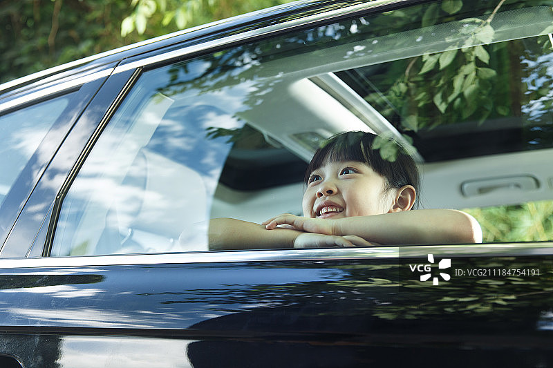 快乐的小女孩坐在车里图片素材