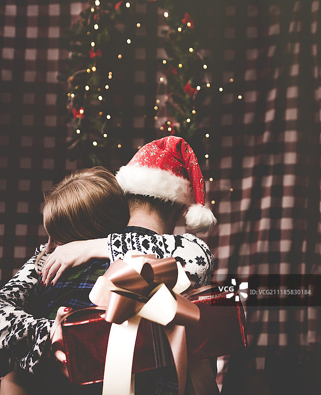 圣诞节女孩抱着男友，手里拿着礼物图片素材