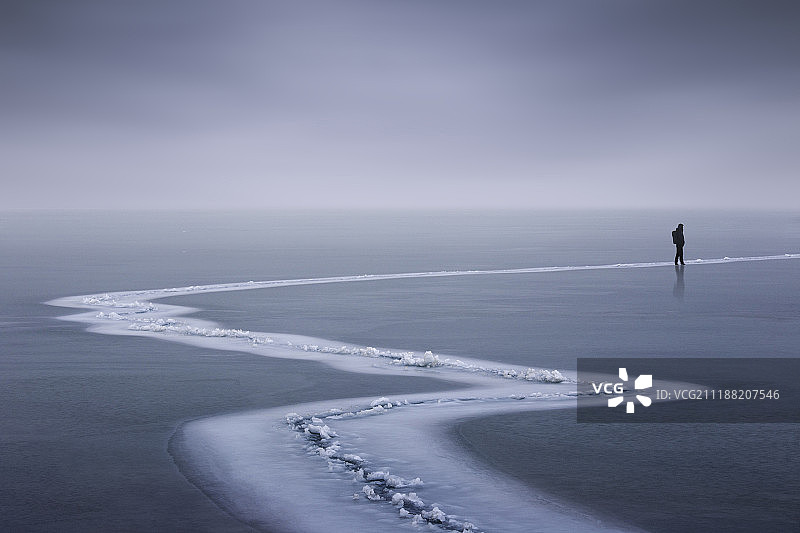 青海省冻结湖面上的一个背包客图片素材